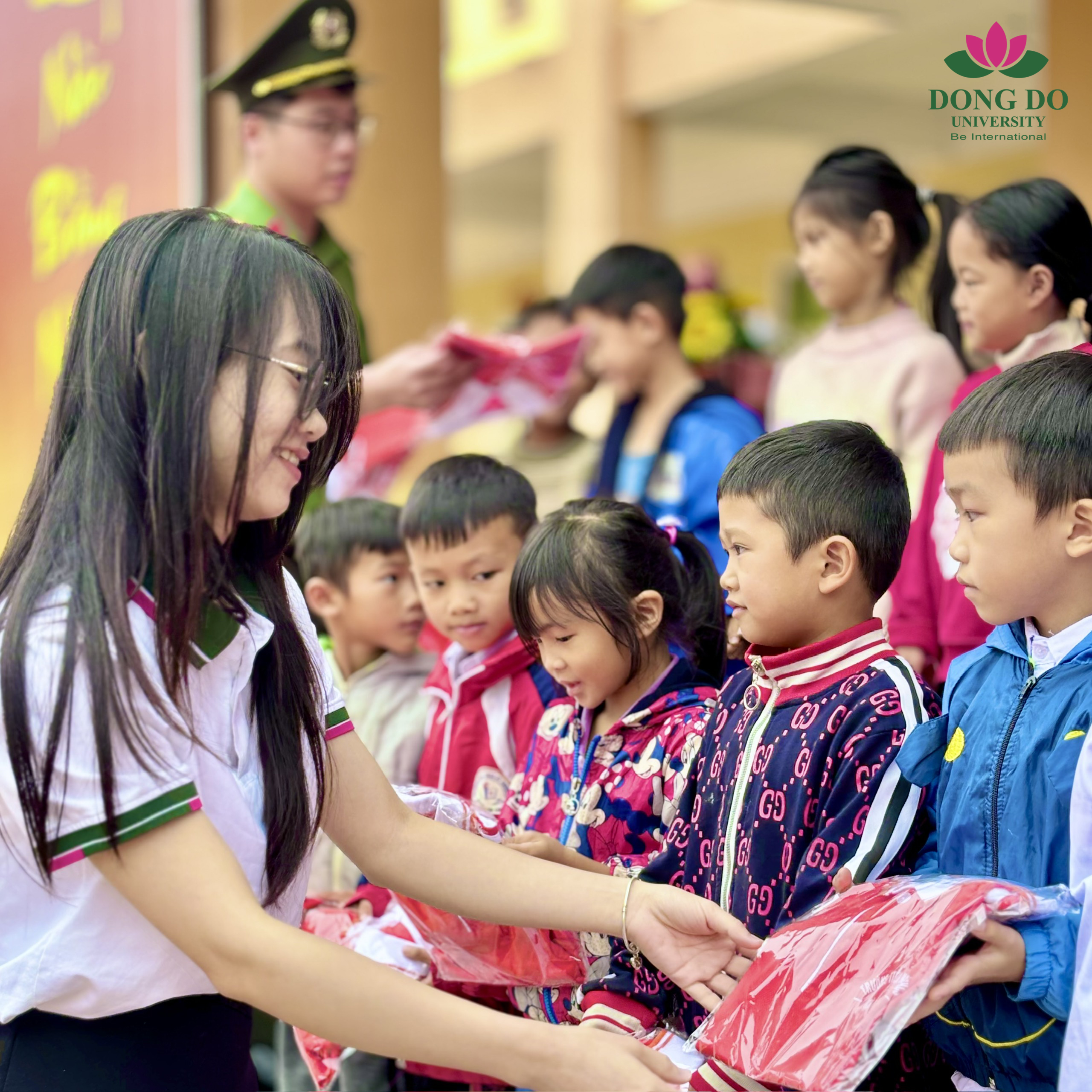 Đồng chí Nguyễn Thị Ngọc Anh - Đại diện Đoàn thanh niên Trường Đại học Đông Đô trao tận tay những chiếc áo đồng phục mới cho các em nhỏ